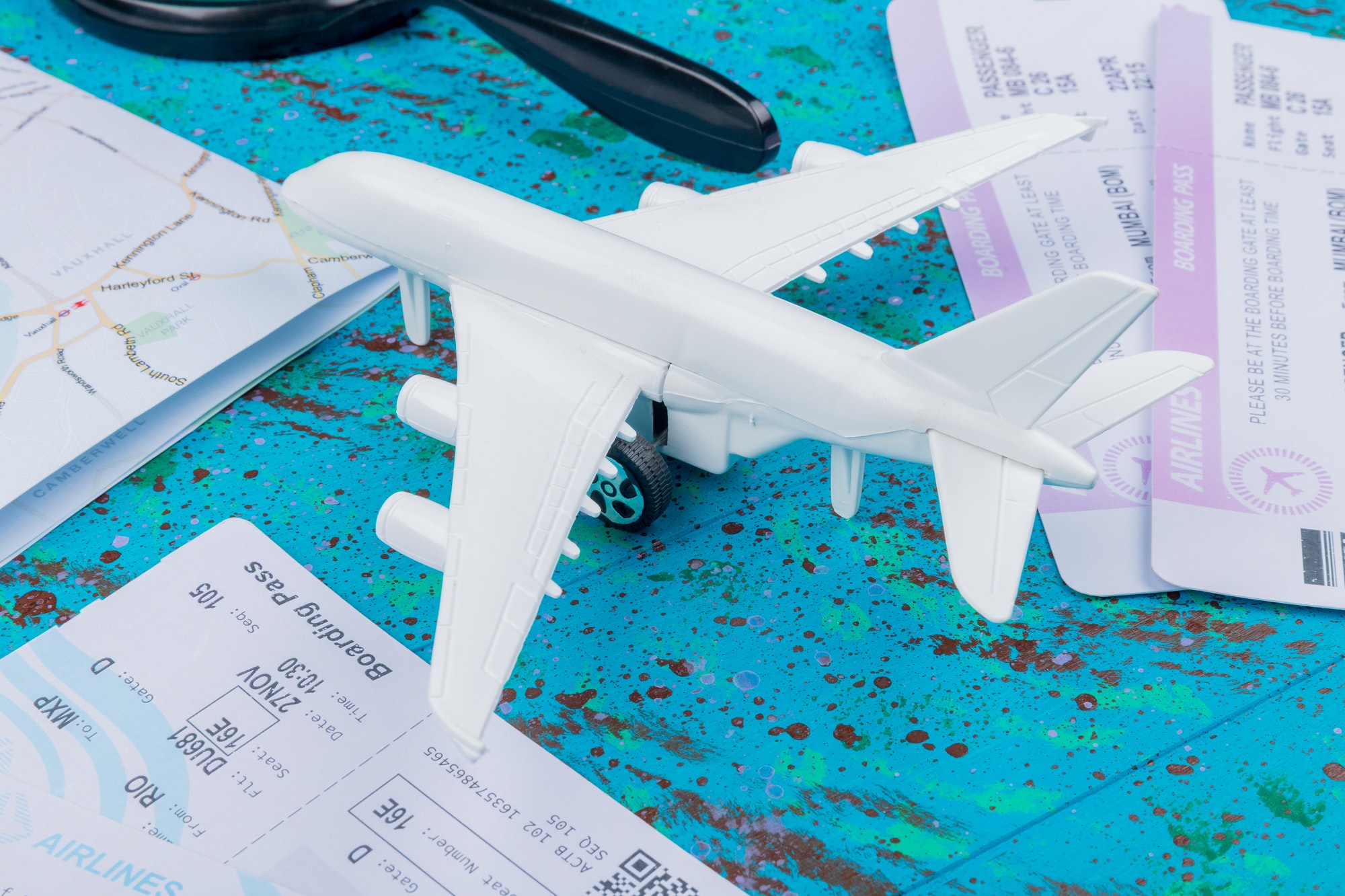 top view of white model airplane with plane tickets on a blue background