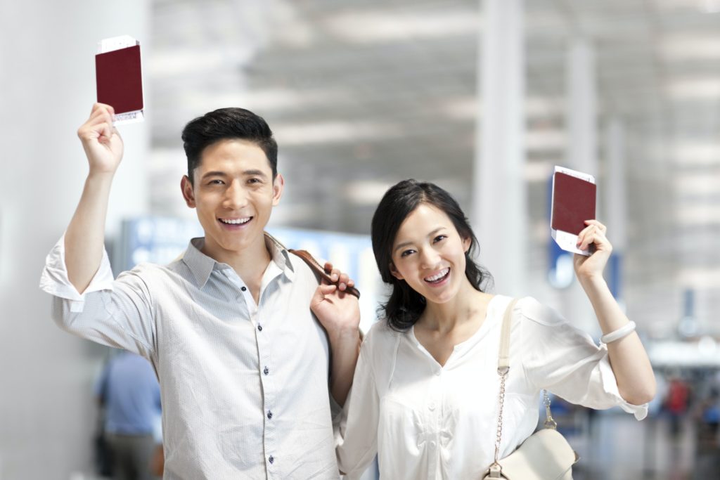 Young couple at the airport with flight tickets and passports