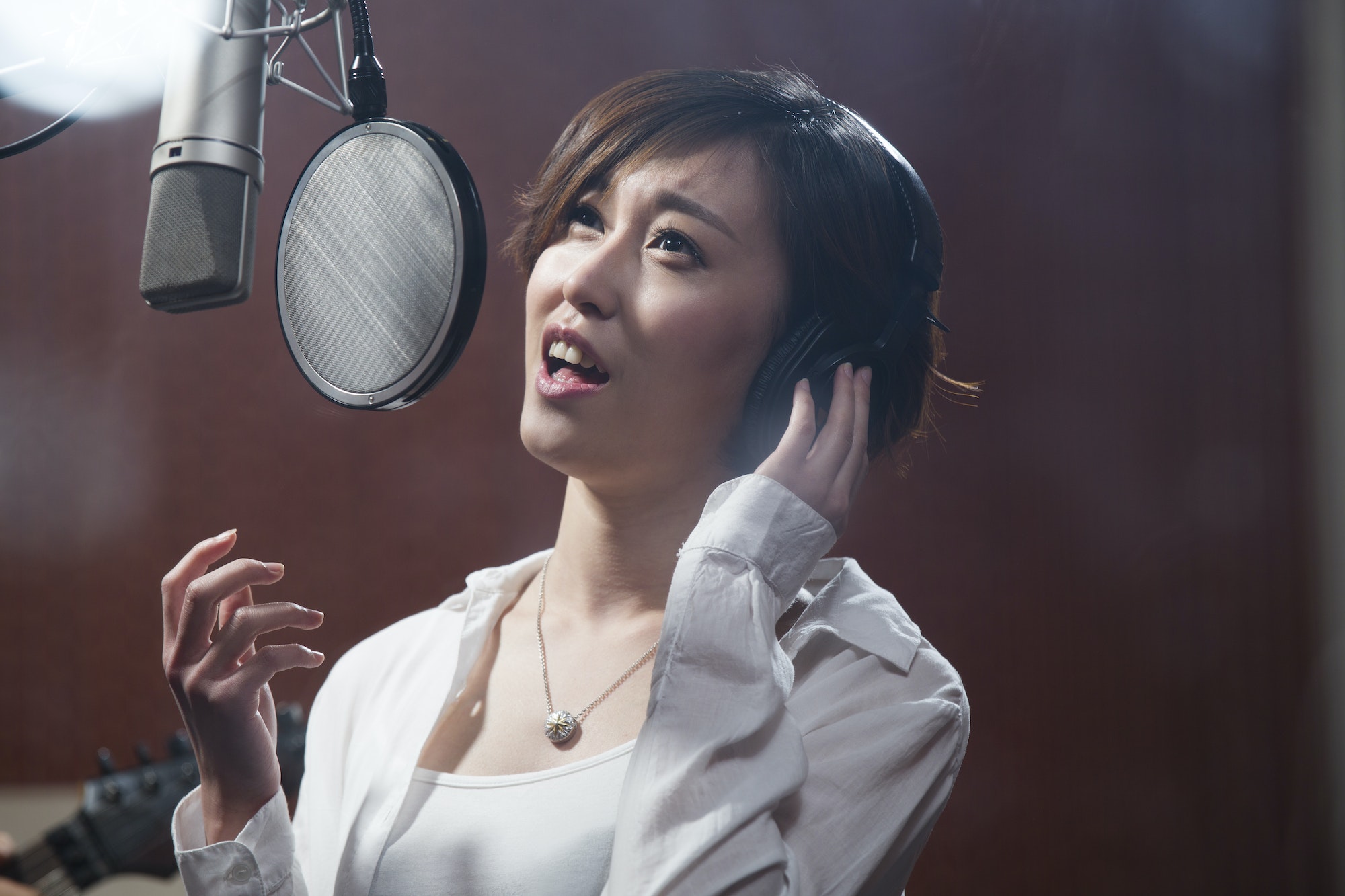 Young woman singing in recording studio