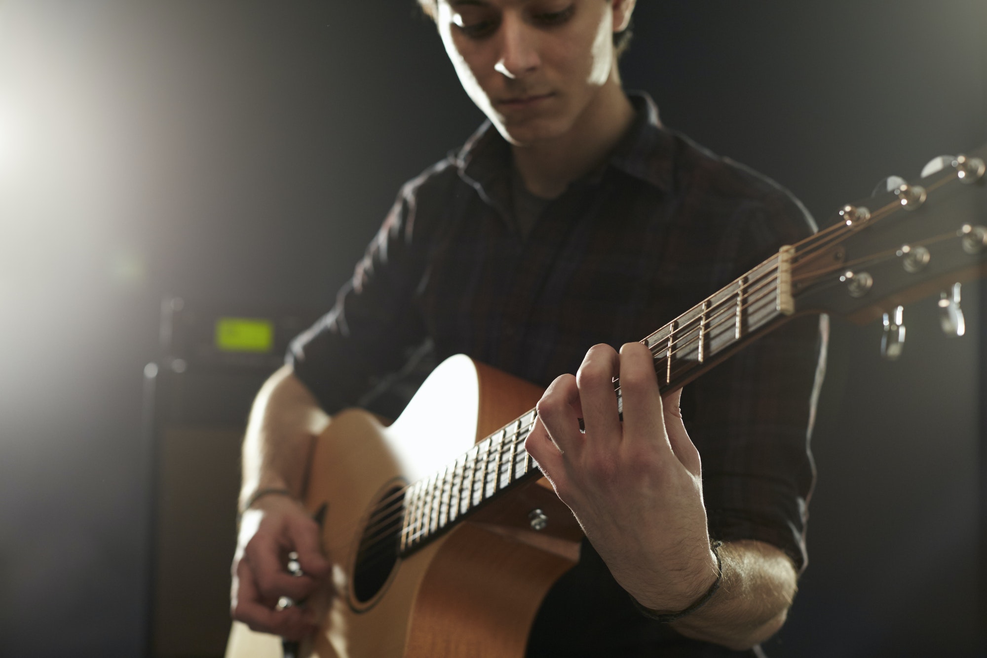 Man Playing Acoustic Guitar In Studio