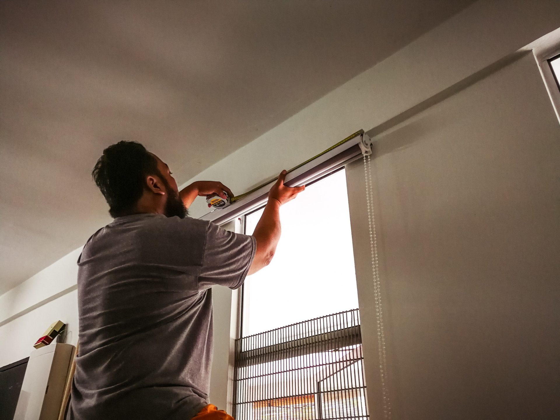 Man measure and install curtain panel at the window. do it yourself, diy, man at work.