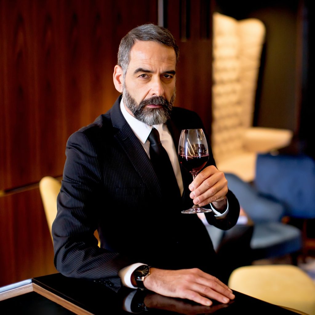 Handsome elegant businessman drinking red wine