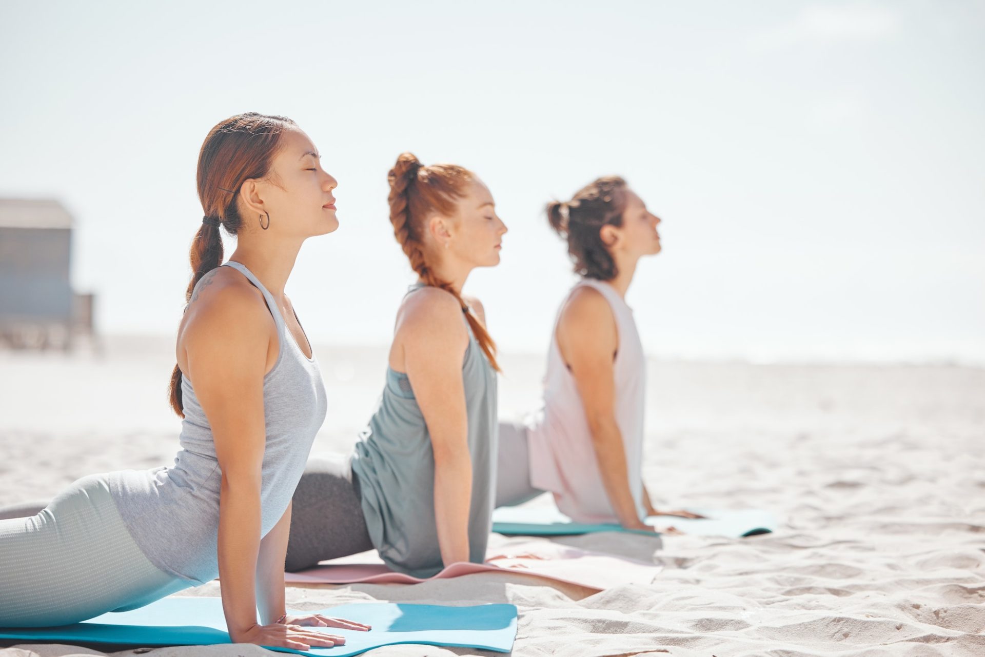 Team yoga on beach, relax meditation in nature and zen during pilates class at the sea, collaborati